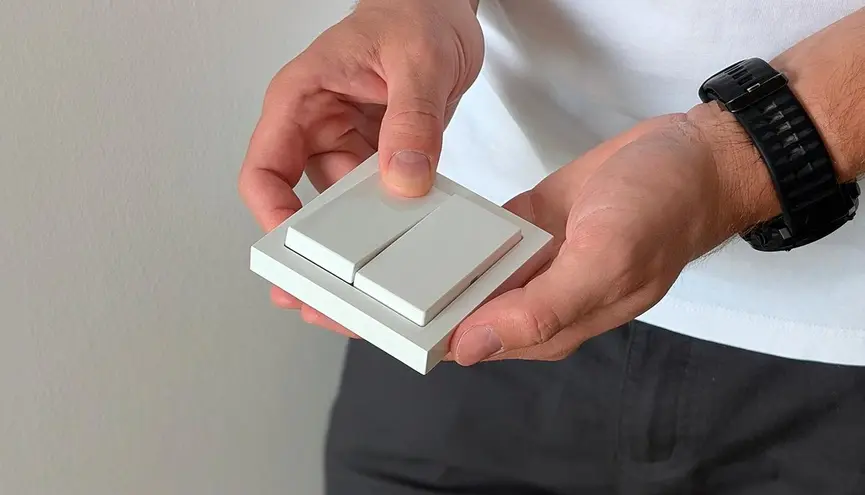 Ruce drží bezdrátový vypínač ke světlu